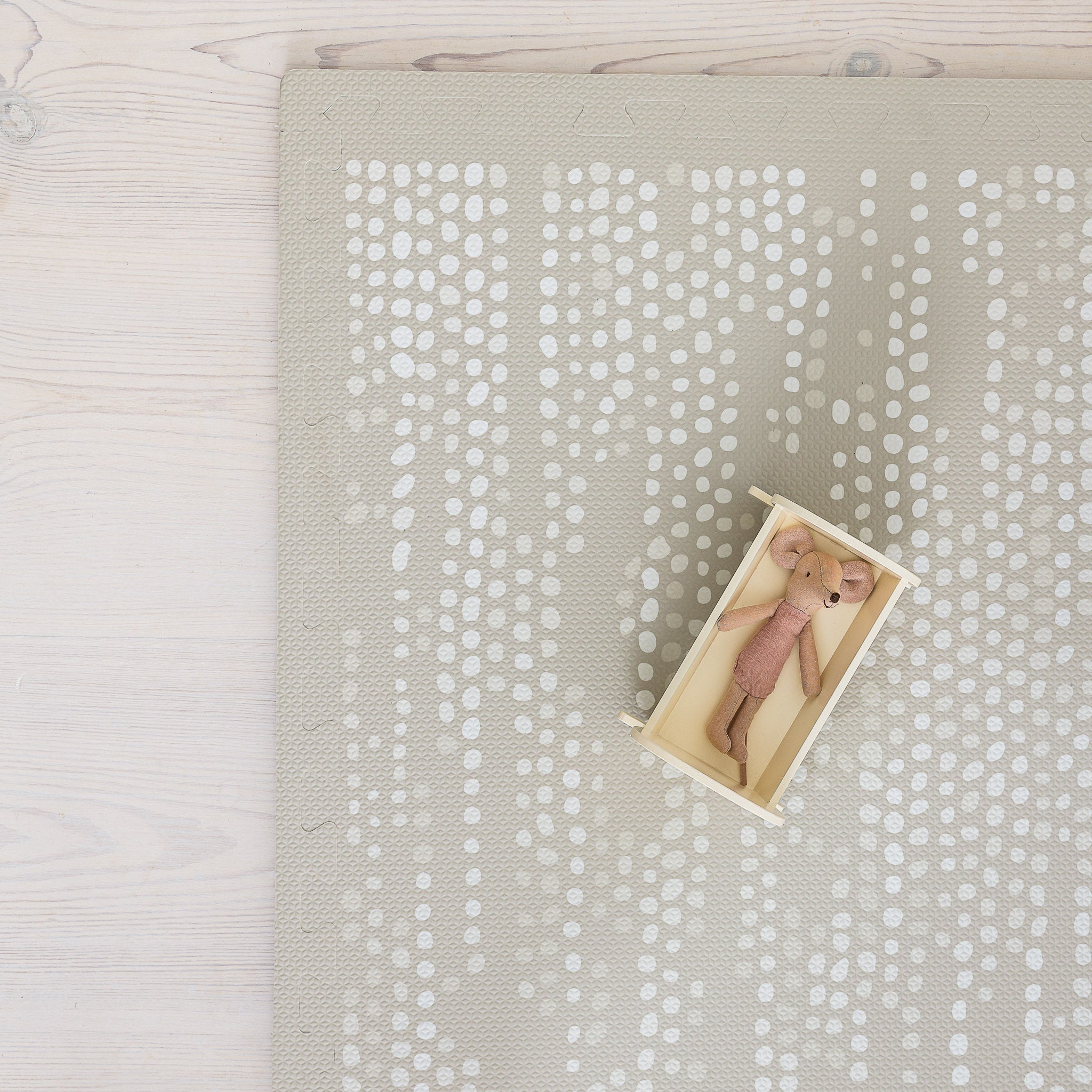 Child playing with wooden toys on Dots Stone foam play mat